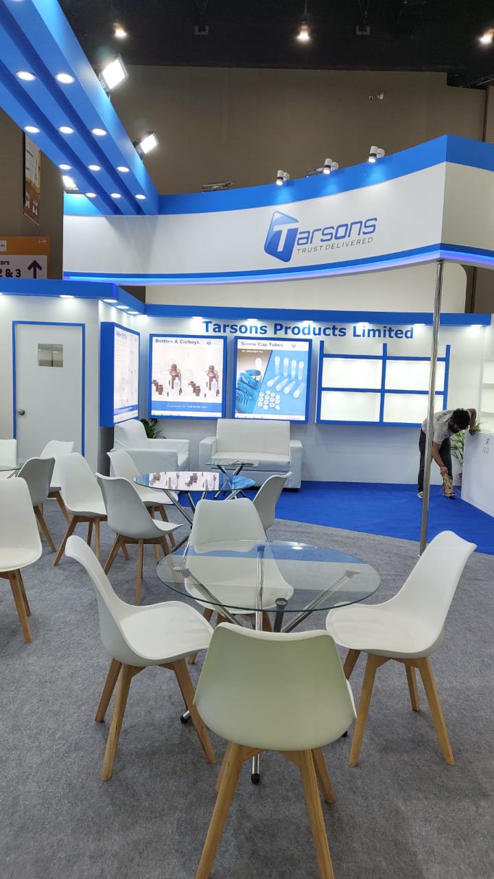 Tarsons stall — tall view of the curved illuminated fascia and roll-up banners